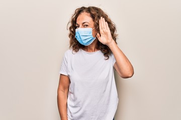 Middle age woman wearing coronavirus protection mask for covid-19 epidemic virus smiling with hand...