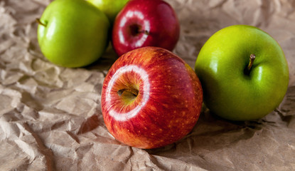 Fresh red and green apples on  beige texture background. Crumpled paper.