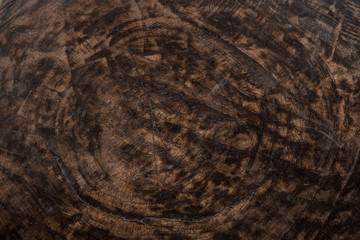Old wooden oak tree cut surface. Detailed warm dark brown and orange tones of a felled tree trunk or stump. Natural wooden background. Rough organic texture of tree rings.