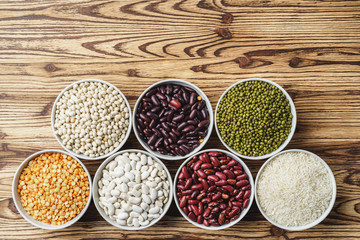 Assortment of beans on wooden background.