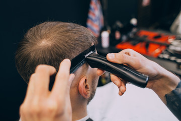 Barbershop Close-up of barber holds clip-on hair clipper