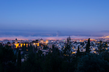 View of the Alhambra and the Generalife and the city of Granada from the viewpoint of the Silla del Moro at sunrise.