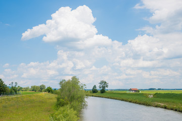 Fototapeta na wymiar idyllic Loisach river, green meadow and wooden hut, cloudy sky