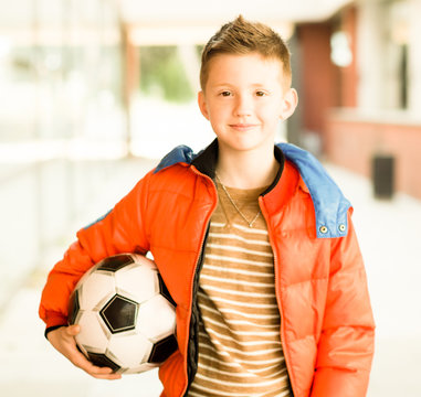 boy in red jacket with soccer Ball