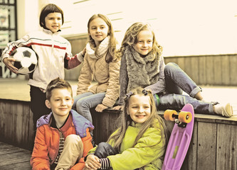 group of children sitting on wooden scaffolding schoolyard
