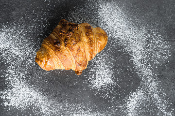 Photograph of a recently baked traditional croissant, a delicious snack.