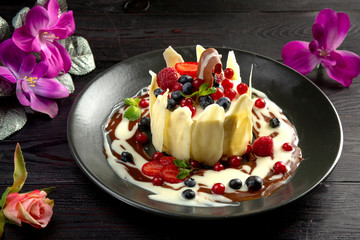 milk dessert with fruit and chocolate on a dark background