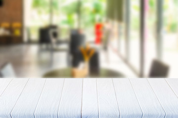 White wooden table in coffee shop blurred background.