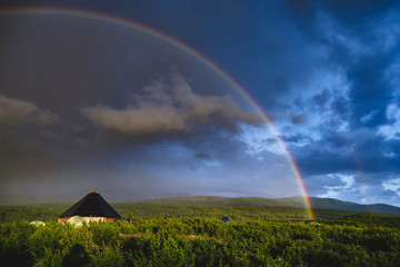 Ail the traditional altai house and tourist tents around under the rainbow in the Ongudaysky...