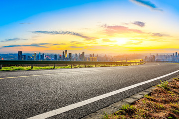 Empty asphalt road and Chongqing city skyline and buildings at sunset,China.