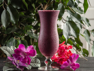 Cocktail with fruits and berries in a tall glass on a dark background