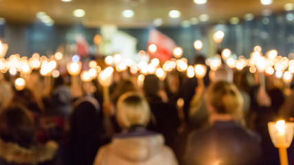 Defocused Image Of Crowd With Illuminated Candles In Church