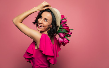 Like in Paris. Brunette woman in a straw hat is looking in the camera over her shoulder, while...