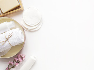care products cream, lotion, cotton pads, plant, soap, towel. bath accessories on white background, top view, copyspace. Bodycare beauty treatments at home concept, organic products, morning routine