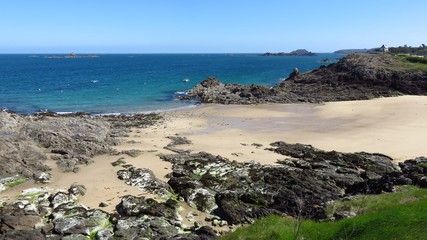 Fototapeta na wymiar Plage déserte à Saint-Malo en Bretagne : plage de la Varde, avec des rochers, à Rothéneuf (France)
