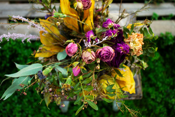 Dry flowers bouquet outside clouse uo on the green and wooden background