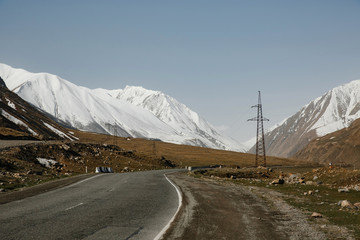 Snow-capped mountains and paved road in Georgia. The Georgian military road