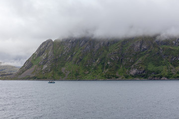 ship sailing on the blue water of the norwegian fjords in polar day, midnight sun