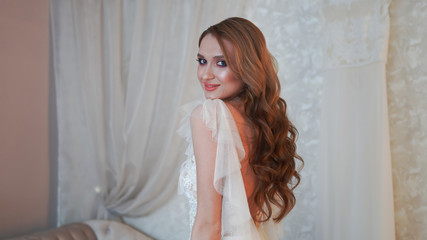 Naklejka premium Girl model in a white dress posing in front of the photographer.