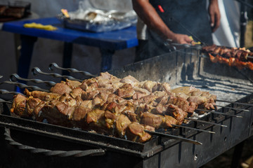 Slice pieces of meat on the grill. barbecue at the festival. Cheese and roasted veal on skewers.Cooking at the festival.