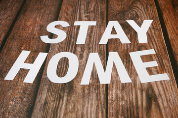Stay home, stay safe slogan from white paper on wooden background, protection measure from...