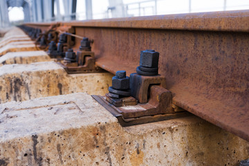 Railway rail, beams, and bolts with reinforcement close up. Railway track
