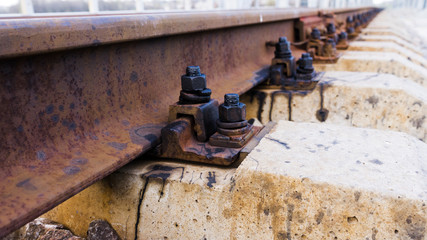 Fototapeta na wymiar Railway rail, beams, and bolts with reinforcement close up. Railway track 