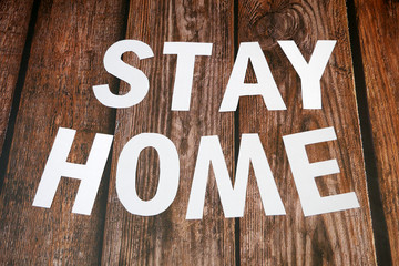 Stay home, stay safe slogan from white paper on wooden background, protection measure from...