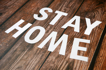 Stay home, stay safe slogan from white paper on wooden background, protection measure from...