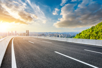 Empty asphalt road and Chongqing city skyline and buildings at sunset,China.