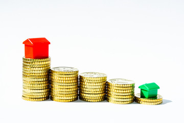 stacks of gold coins with red and green houses, business and financial motives, housing topics, investments, coins, money, banking topics with coins and red houses