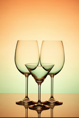 Three wine glasses on an orange-green background