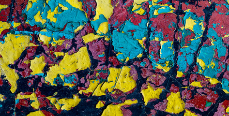 Abstract vintage multicolored surface in cracked paint. Paint of different colors on the aged and...