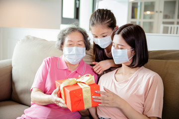 mother and grandmother with daughter wearing face mask to celebrating mothers day
