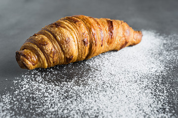 Photograph of a recently baked traditional croissant, a delicious snack.