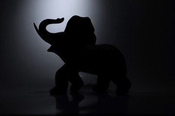 standing ceramic elephant illuminated by white light