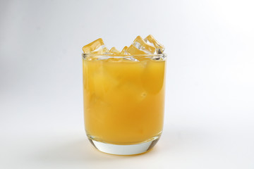 Fresh yellow orange juice in glass with ice cube on white background
