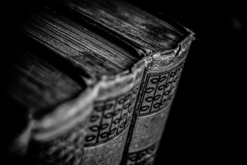 Foto b/n di libri antichi ordinati in una libreria 