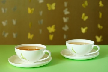 Cups of green tea on a green surface close-up
