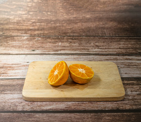 Glass of orange juice and oranges on wooden background. Orange juice on table close-up