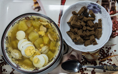 Chicken soup with noodles, carrots, eggs and cheese croutons