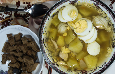 Chicken soup with noodles, carrots, eggs and cheese croutons