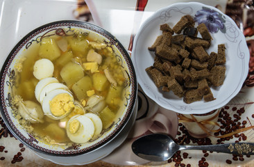 Chicken soup with noodles, carrots, eggs and cheese croutons