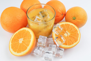 Fresh yellow orange juice in glass with whole sliced orange fruit and ice cube on white background