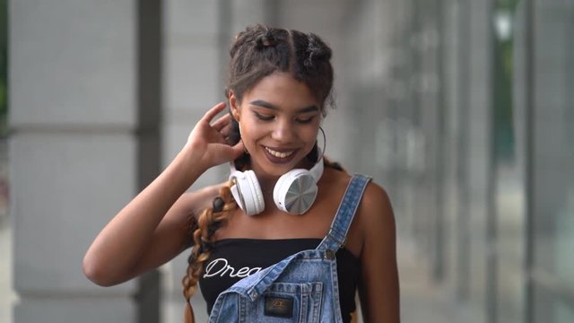 Photo of teenage girl with headphone posing on the street.