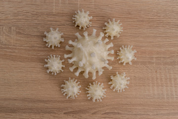 Obraz na płótnie Canvas covid19, 3d printed representation of the virus on a wooden surface. home security and protection against viruses