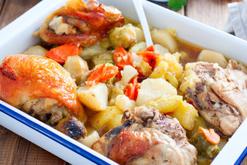 Baked chicken thighs with brussels sprouts, potatoes, carrots, onions, selective focus