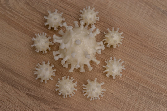 covid19, 3d printed representation of the virus on a wooden surface. home security and protection against viruses