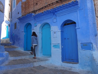 Naklejka premium A woman and staircase in the beautiful blue old town, Medina, Chaouen (Chefchaouen), Morocc