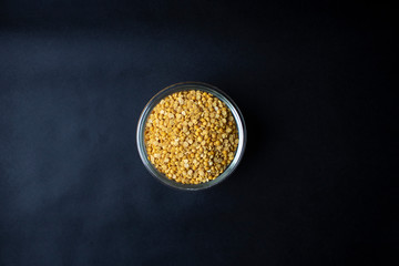 Yellow split pigeon peas dal on black background with copy space and isolated top view